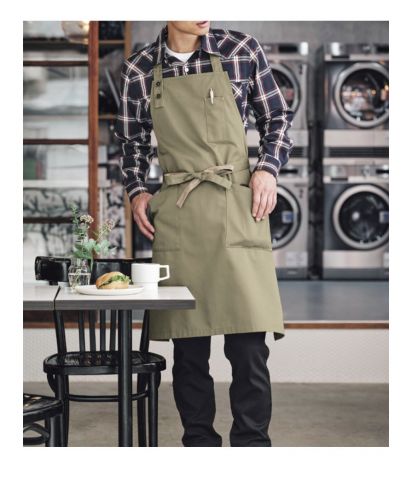 フェイスミックス(FACE MIX)胸当てエプロン/カーキ×ベージュの胸当てエプロンFK7193を着用した男性スタッフ。撥水ツイル素材で汚れに強く、飲食店・ベーカリー・カフェの制服におすすめ。大容量ポケットと肩ひもボタン調整機能で、デザイン性と実用性を両立。